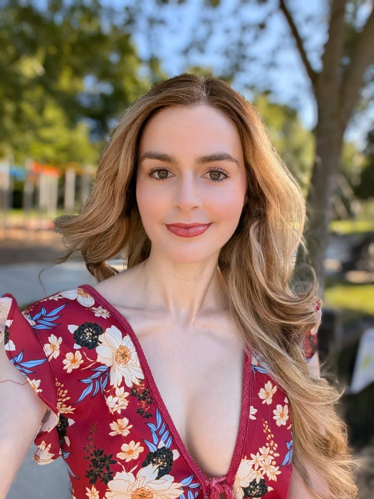 Pip in a red floral dress, outdoors on a sunny day