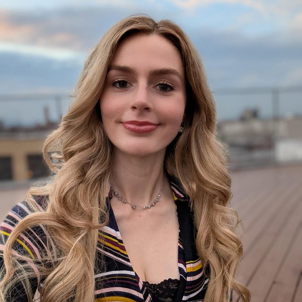 Close-up of Pip on a rooftop at dusk, in a striped top